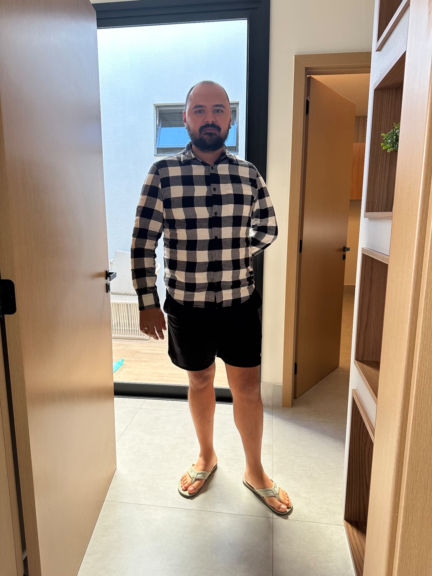 Wennder usando camisa xadrez, bermuda e chinelos para entrar em uma reunião
