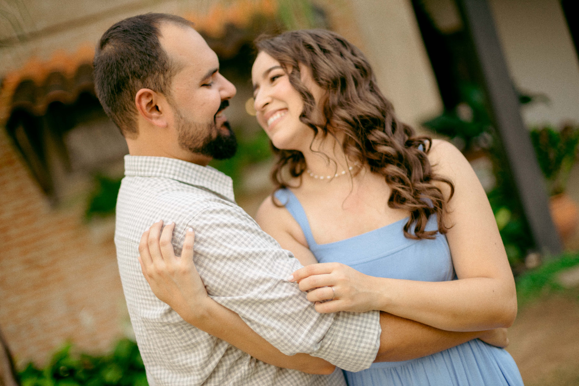 Daniela e Wennder sorrindo juntos diante da casa de campo