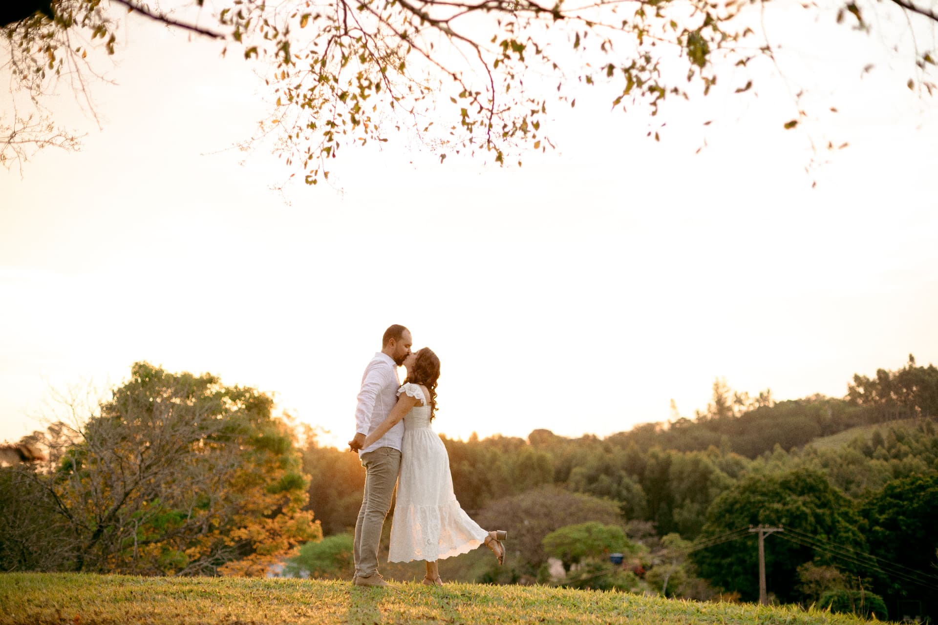 Daniela e Wennder se beijando na paisagem do campo
